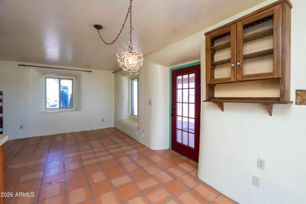 a view of a livingroom with a dinning area closet and chandelier