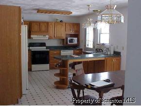 2275 Booth Road Hallstead, PA 18822 - Photo 3 of 5 a kitchen with granite countertop a stove a sink and a refrigerator