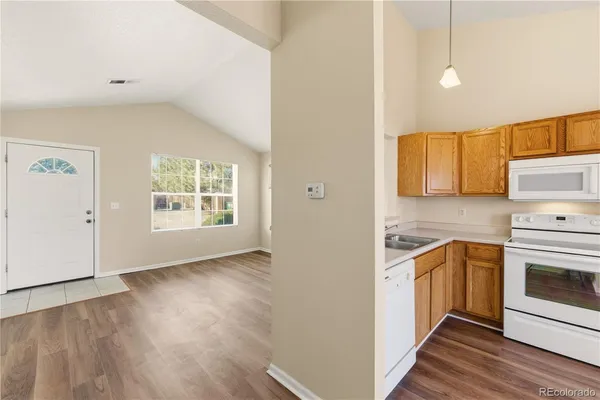 a view of a kitchen with wooden floor and electronic appliances