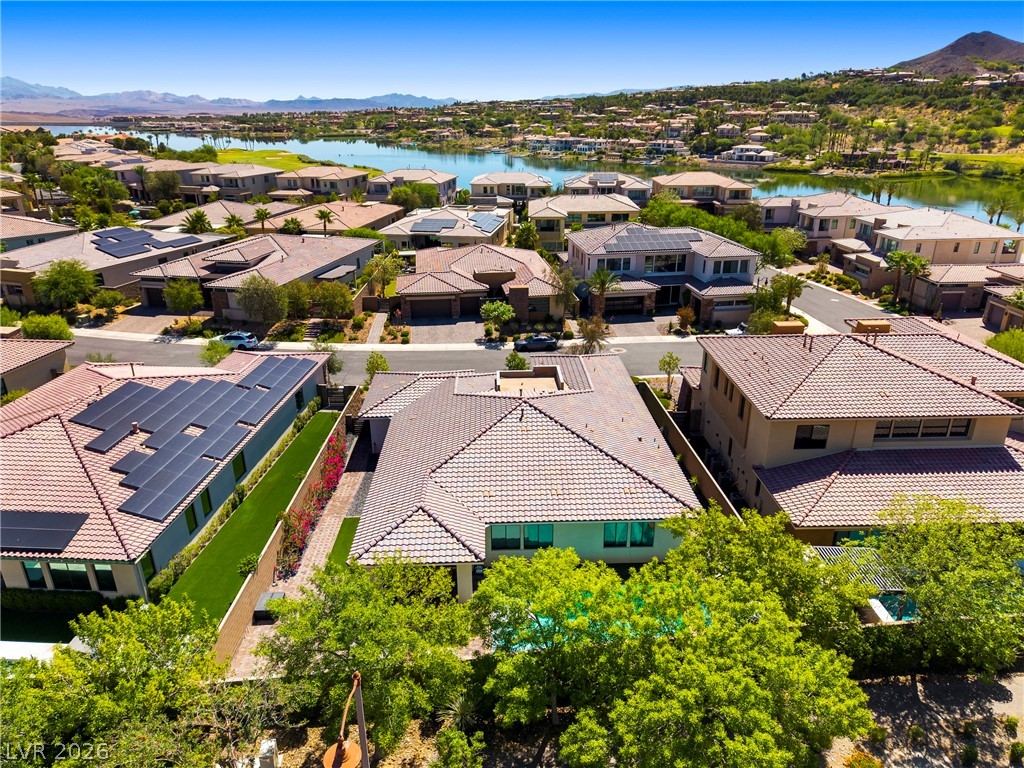 45 Garibaldi Way Henderson, NV 89011 - Photo 50 of 74 An aerial perspective reveals a luxurious lakeside community nestled against a majestic mountain backdrop.