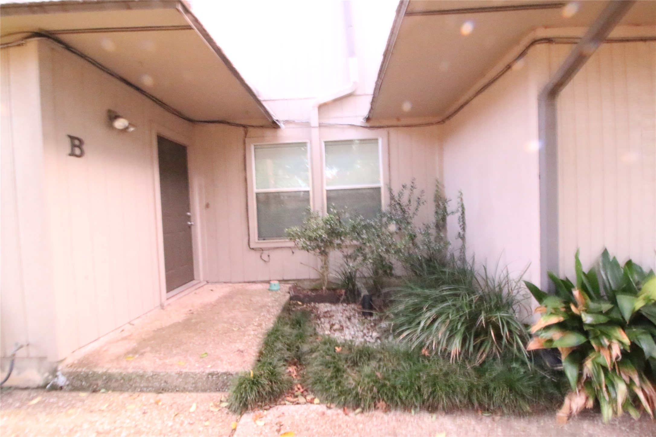 703 Castle Ridge Road, Unit B Austin, TX 78746 - Photo 1 of 5 A welcoming front entrance featuring mature landscaping and a well-maintained pathway.
