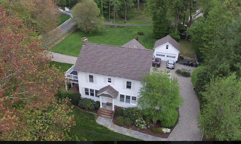 an aerial view of a house with yard and green space
