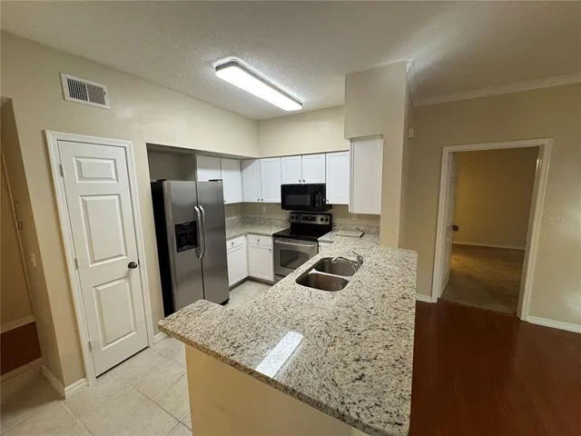 a kitchen with stainless steel appliances granite countertop a refrigerator and a sink