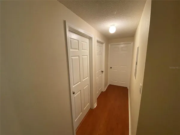 a view of a hallway with wooden floor