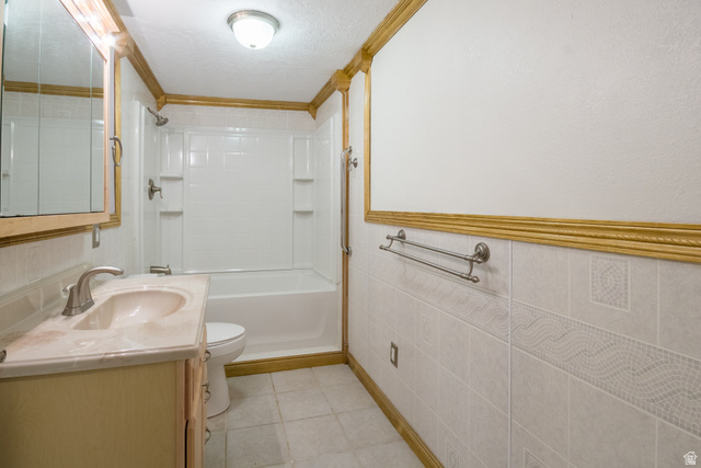 634 South 2100th Street West Vernal, UT 84078 - Photo 40 of 71 Full bathroom featuring a single vanity with an integrated sink, a built-in bathtub with shower, and decorative wall tiling