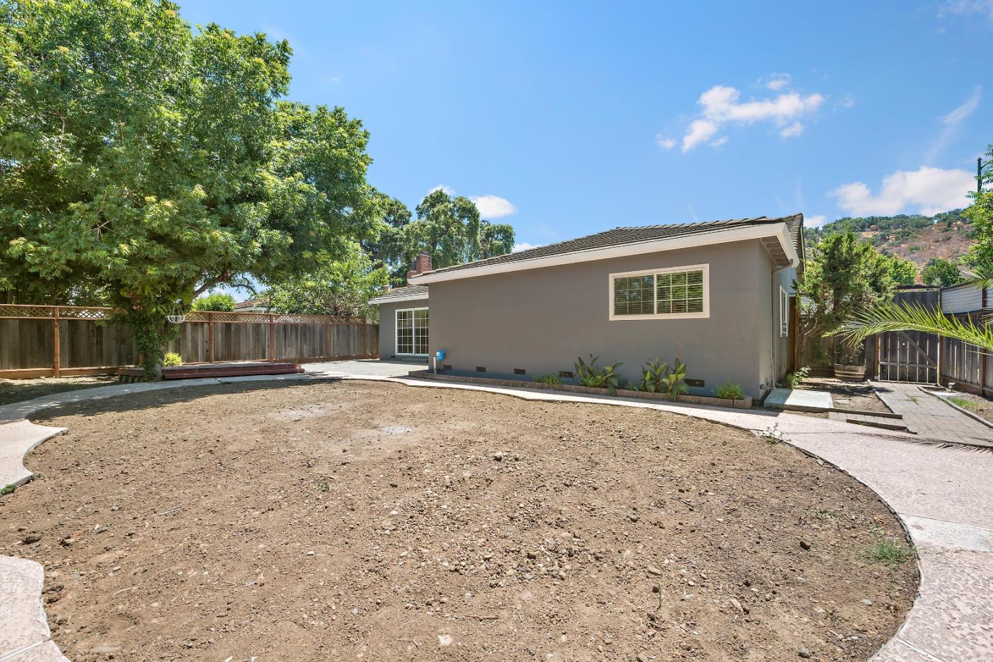 929 Maclay Drive San Jose, CA 95123 - Photo 21 of 23 a backyard of a house with table and chairs under an umbrella
