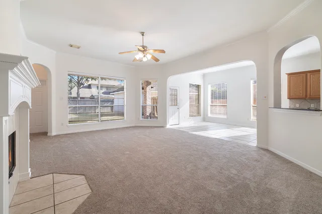 an empty room with windows and fan