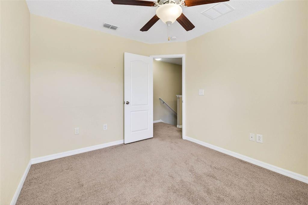 31253 Claridge Place Wesley Chapel, FL 33543 - Photo 31 of 37 an empty room with a ceiling fan and carpet