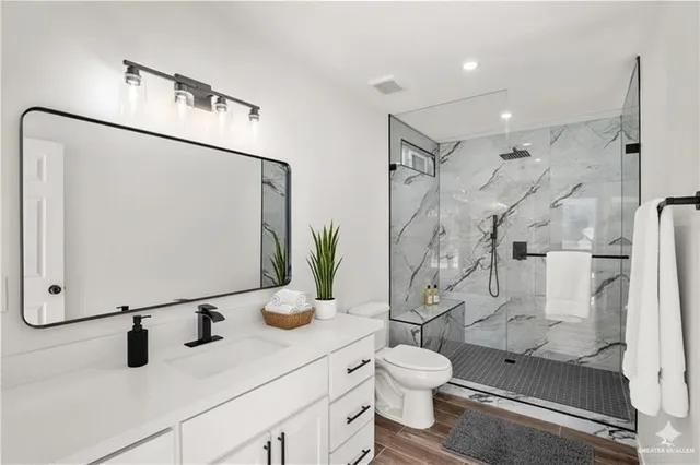 a bathroom with a granite countertop sink toilet and shower