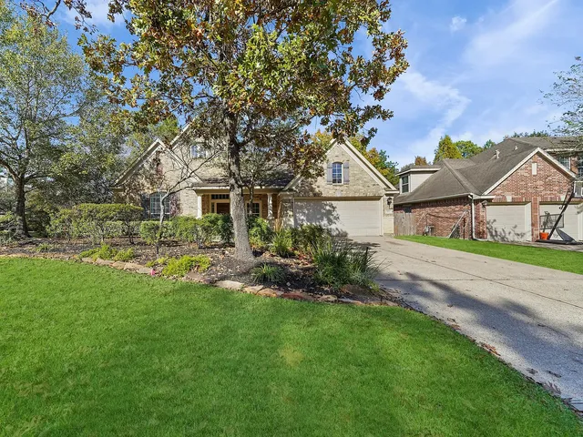 a view of house with a big yard couches and large trees