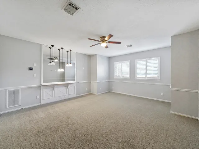 an empty room with closet and a ceiling fan