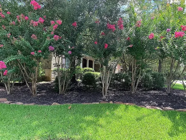 a backyard of a house with lots of green space and fountain