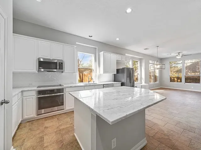 a kitchen with granite countertop a stove and a sink