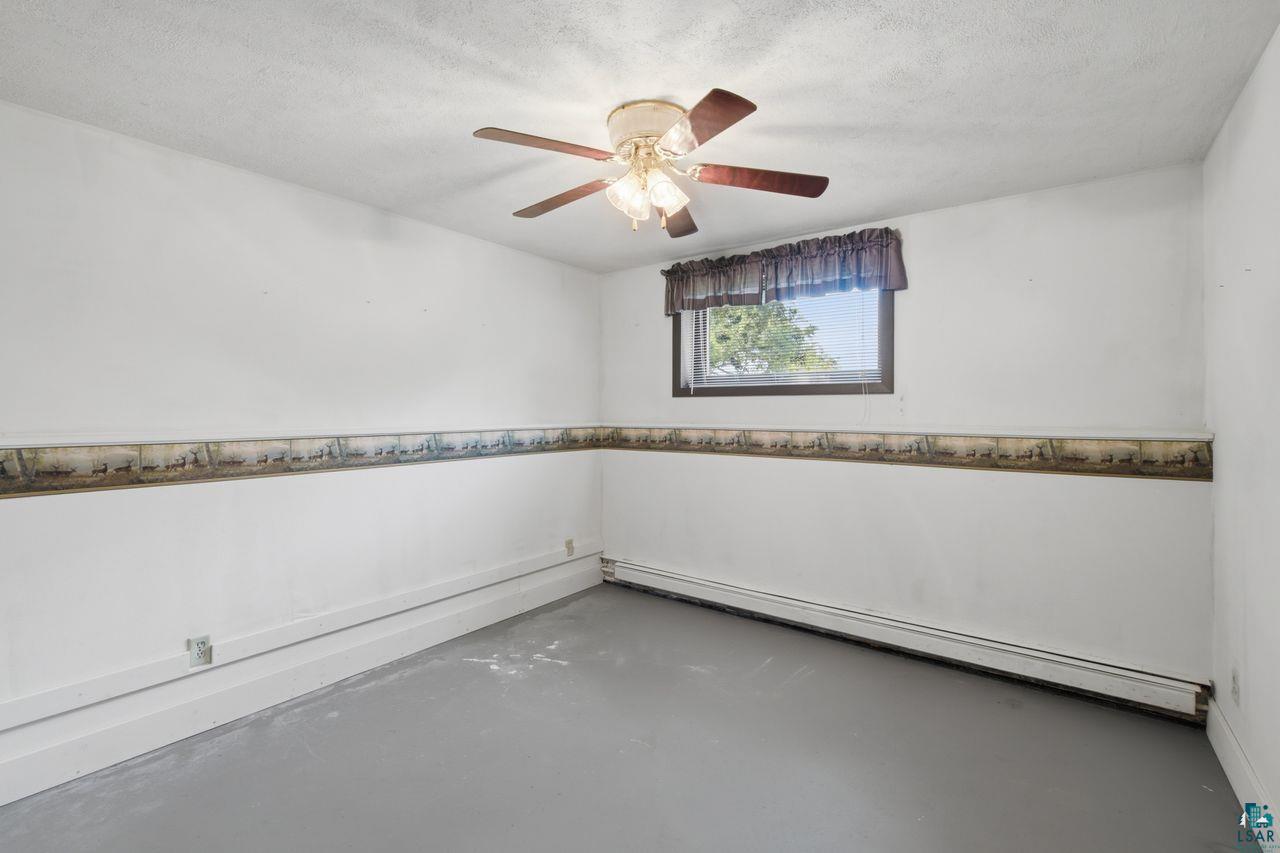61018 Dahlstrom Road Ashland, WI 54806 - Photo 12 of 28 Room with white painted walls, a single window, and a ceiling fan with integrated lighting