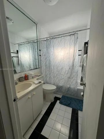 a bathroom with a sink a toilet a mirror and shower