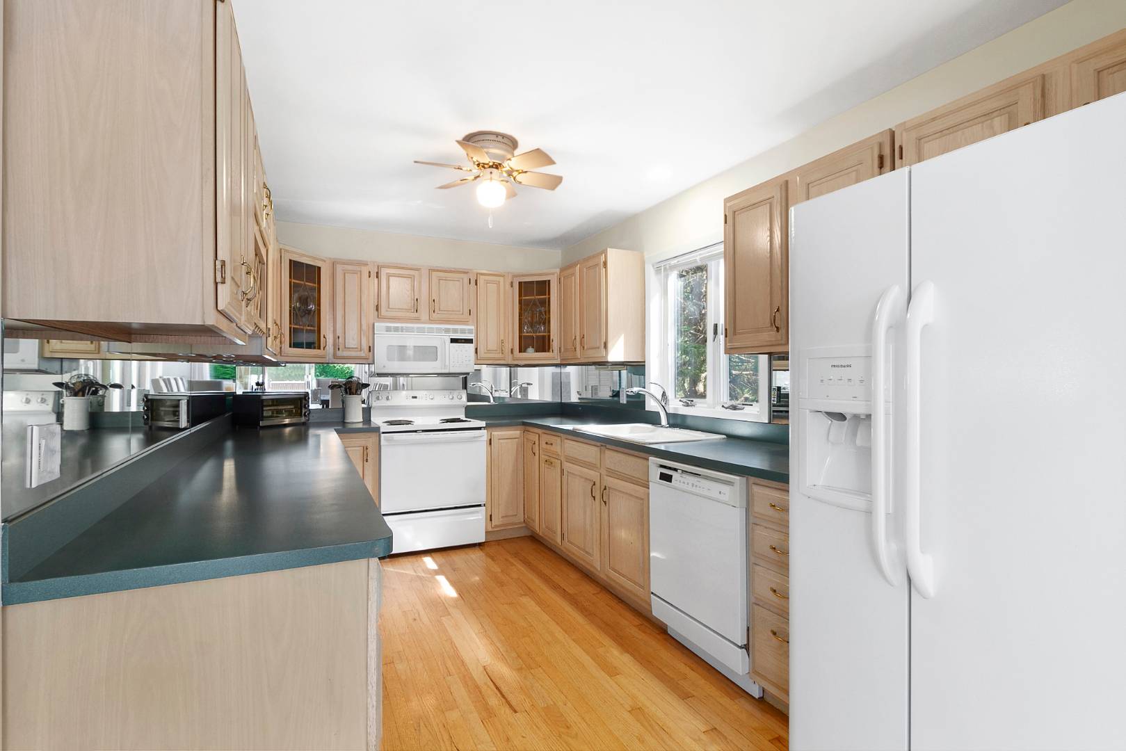 27 Tuthill Lane Remsenburg, NY 11960 - Photo 6 of 18 a kitchen with stainless steel appliances granite countertop a refrigerator a sink dishwasher a stove and white cabinets with wooden floor