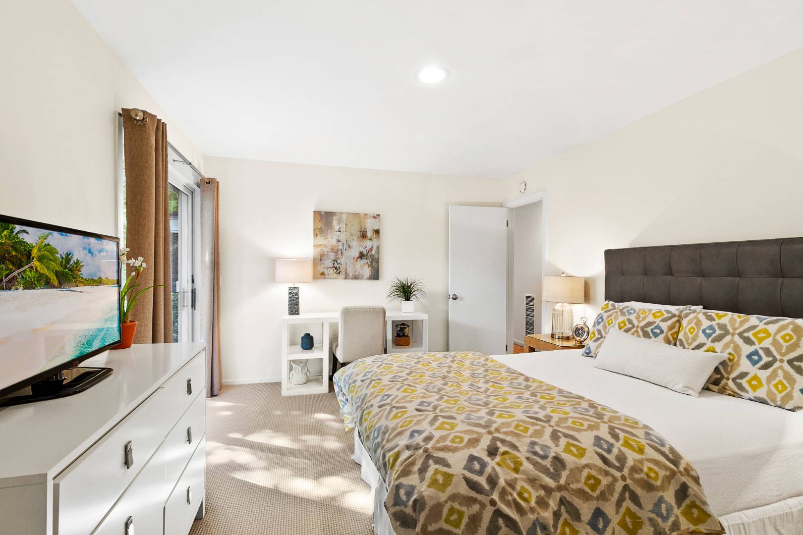 27 Tuthill Lane Remsenburg, NY 11960 - Photo 7 of 18 a bedroom with a large bed and a flat tv screen on dresser