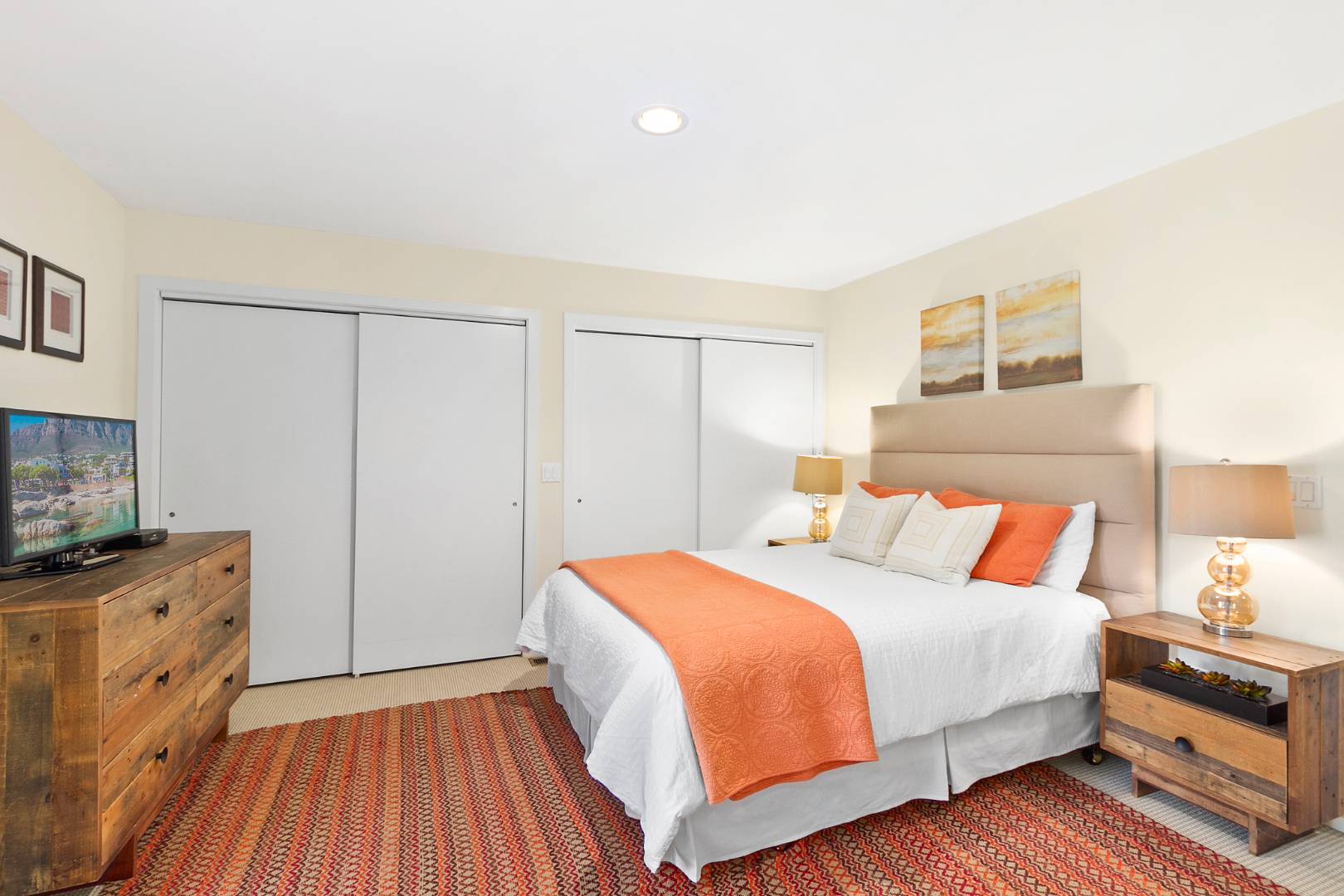 27 Tuthill Lane Remsenburg, NY 11960 - Photo 8 of 18 a bedroom with a bed and a flat tv screen on dresser