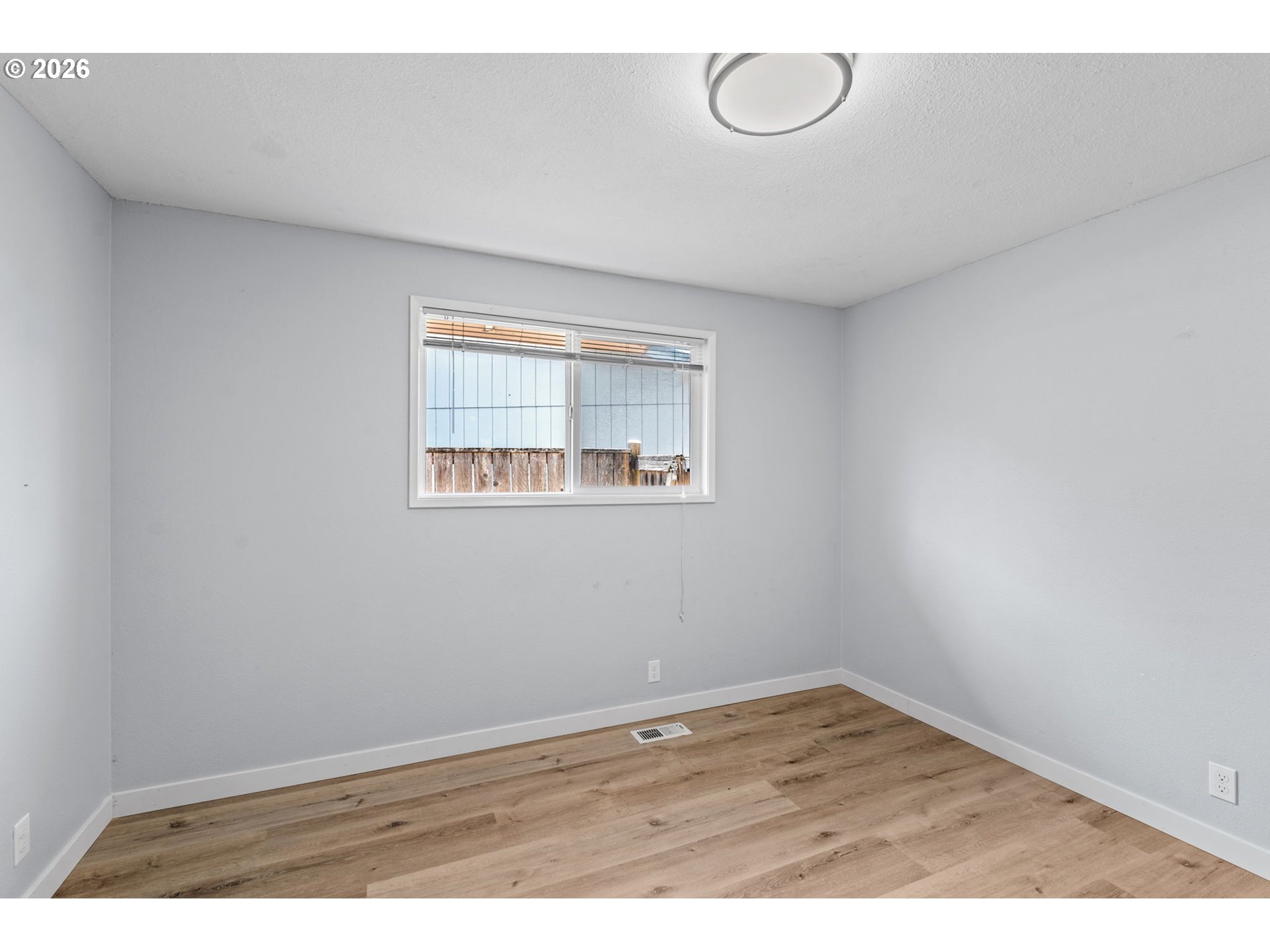 6445 B Street Springfield, OR 97478 - Photo 13 of 26 an empty room with wooden floor and windows