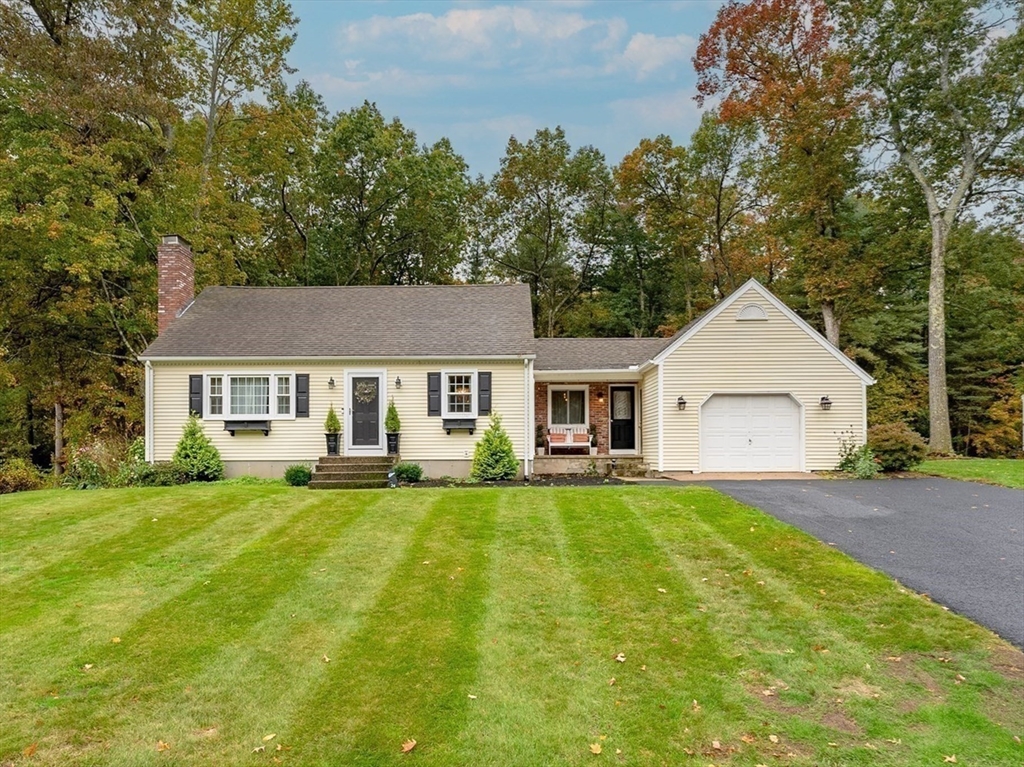 a front view of a house with a garden and trees