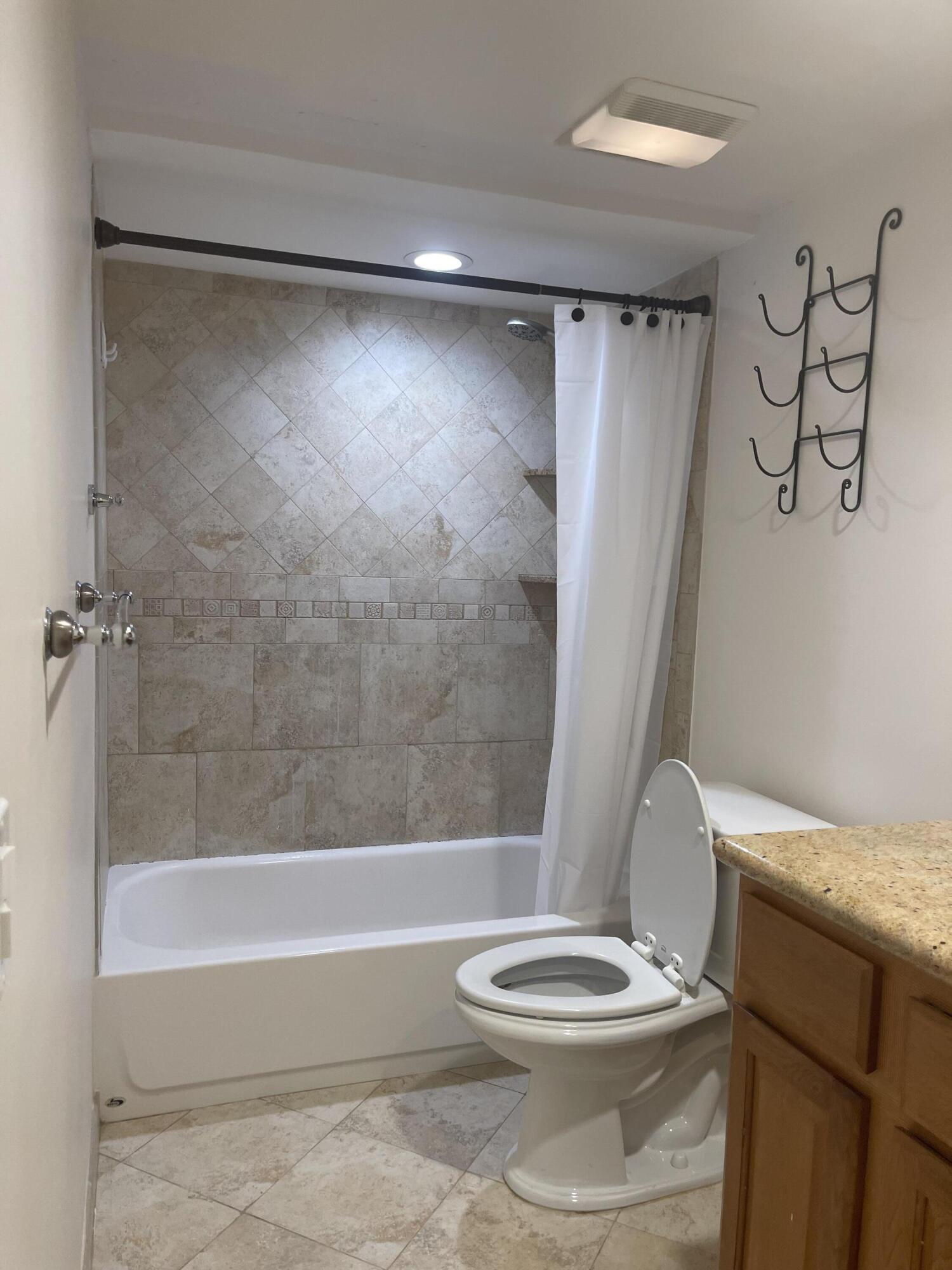 613 6th Lane Palm Beach Gardens, FL 33418 - Photo 7 of 12 a bathroom with a toilet and a shower