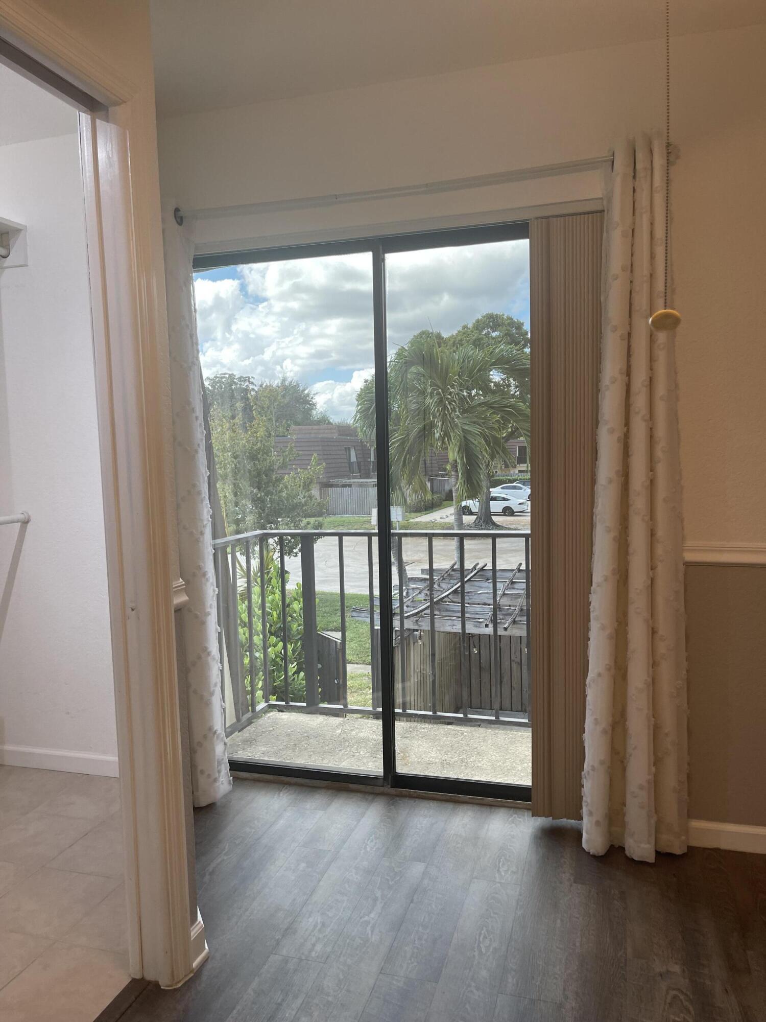 613 6th Lane Palm Beach Gardens, FL 33418 - Photo 9 of 12 a view of empty room with wooden floor and fan
