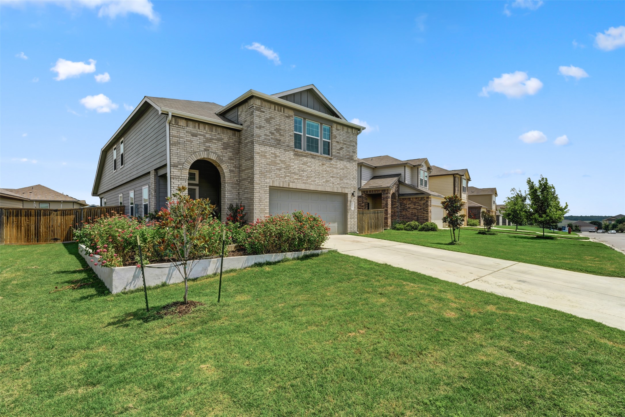 413 Perfect World Loop Jarrell, TX 76537 - Photo 4 of 39 A well-maintained lawn introduces this inviting residence featuring a brick and siding facade with an attached garage.