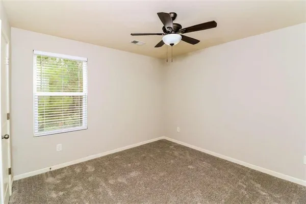 an empty room with a window and a fan