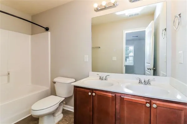 a bathroom with a double vanity sink toilet and shower