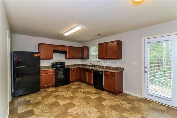 a large kitchen with stainless steel appliances granite countertop a stove a refrigerator and a kitchen island