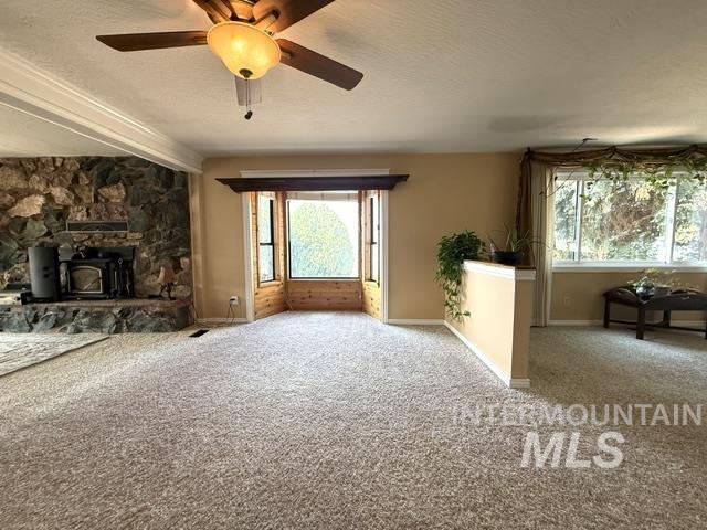 1549 Cove Road Weiser, ID 83672 - Photo 5 of 38 Spacious living area featuring a stone-clad fireplace and wood-burning stove