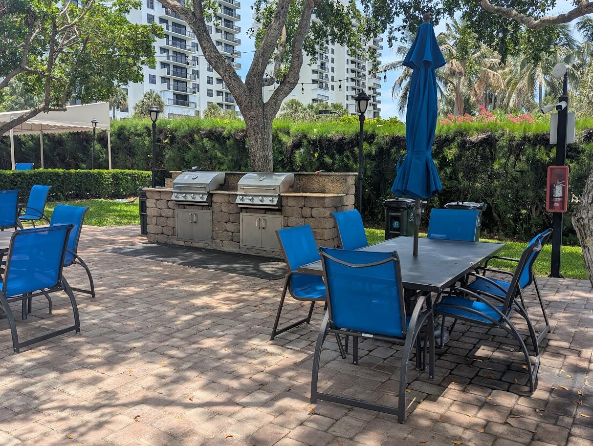 2121 North Ocean Boulevard, Unit 1006E Boca Raton, FL 33431 - Photo 51 of 64 a view of a chairs and table in backyard