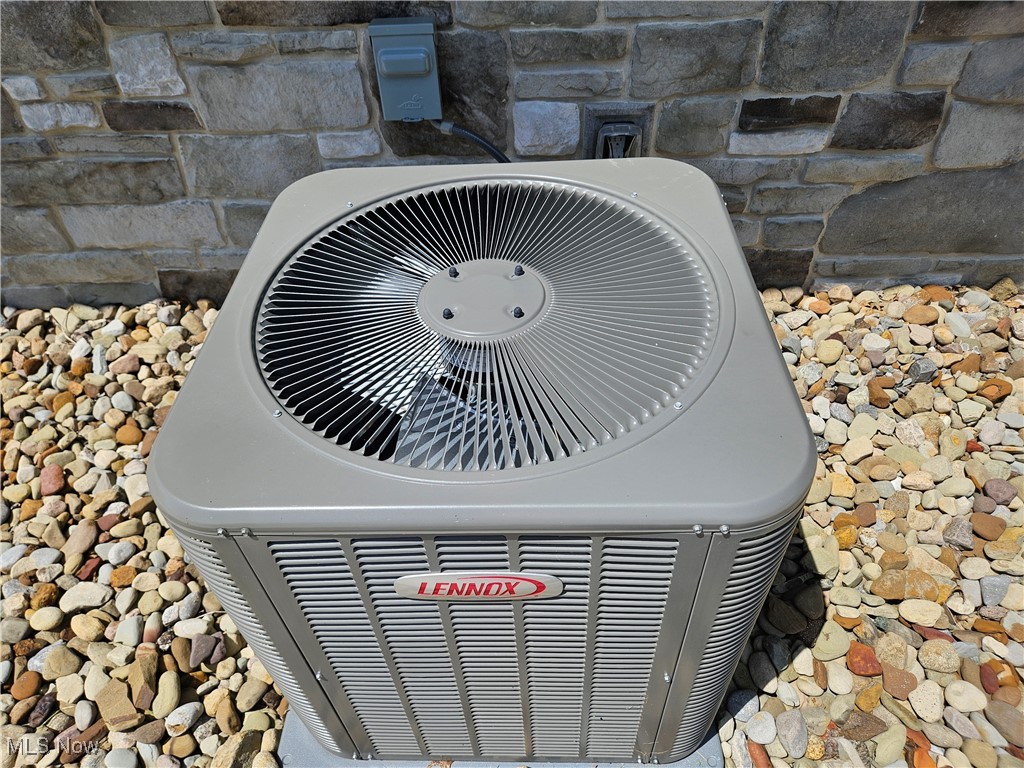 1180 North County Line Road Geneva, OH 44041 - Photo 15 of 33 Exterior view of a cooling unit and stone siding