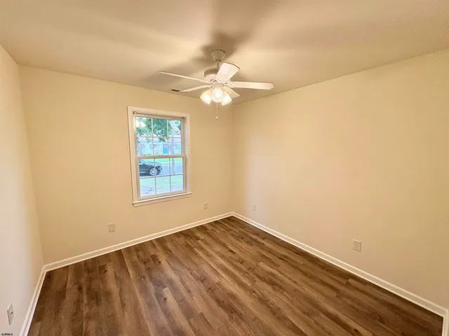 an empty room with a window and a ceiling fan