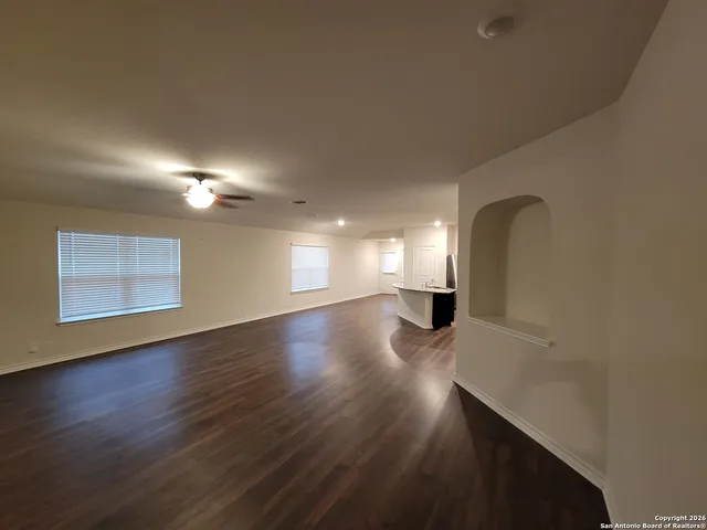 a view of empty room with wooden floor
