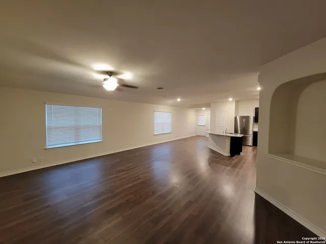 a view of empty room with wooden floor