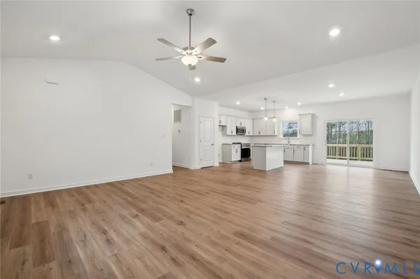 a kitchen with stainless steel appliances granite countertop a sink stove and white cabinets with wooden floor