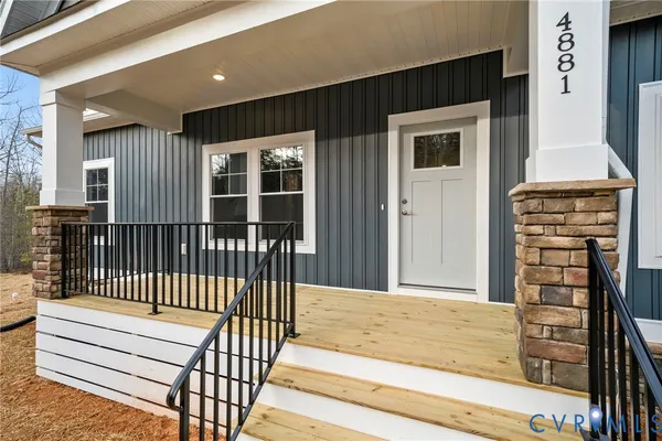 a view of house with a yard and potted plants