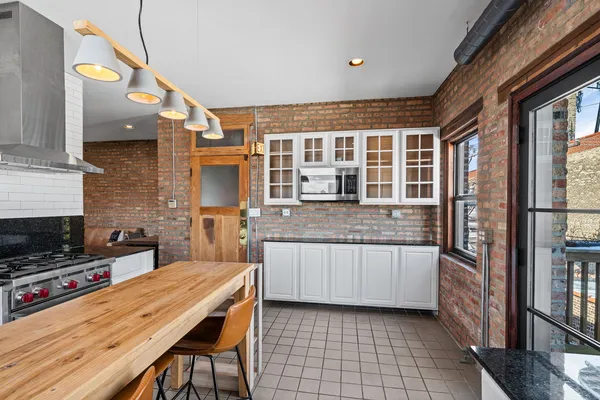 a kitchen with granite countertop a stove a sink and a refrigerator