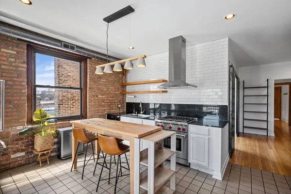 a kitchen with a stove a sink and wooden floor