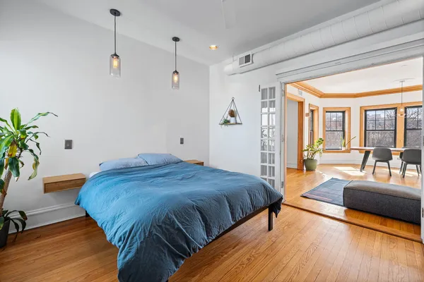 a spacious bedroom with a bed a couch and a potted plant