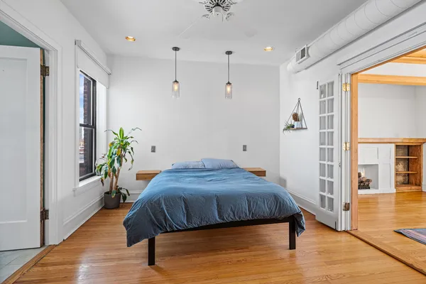 a bedroom with a bed and wooden floor