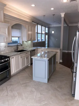 a kitchen with stainless steel appliances granite countertop a stove a sink and a refrigerator