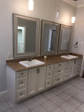 a bathroom with a granite countertop double vanity sink and mirror