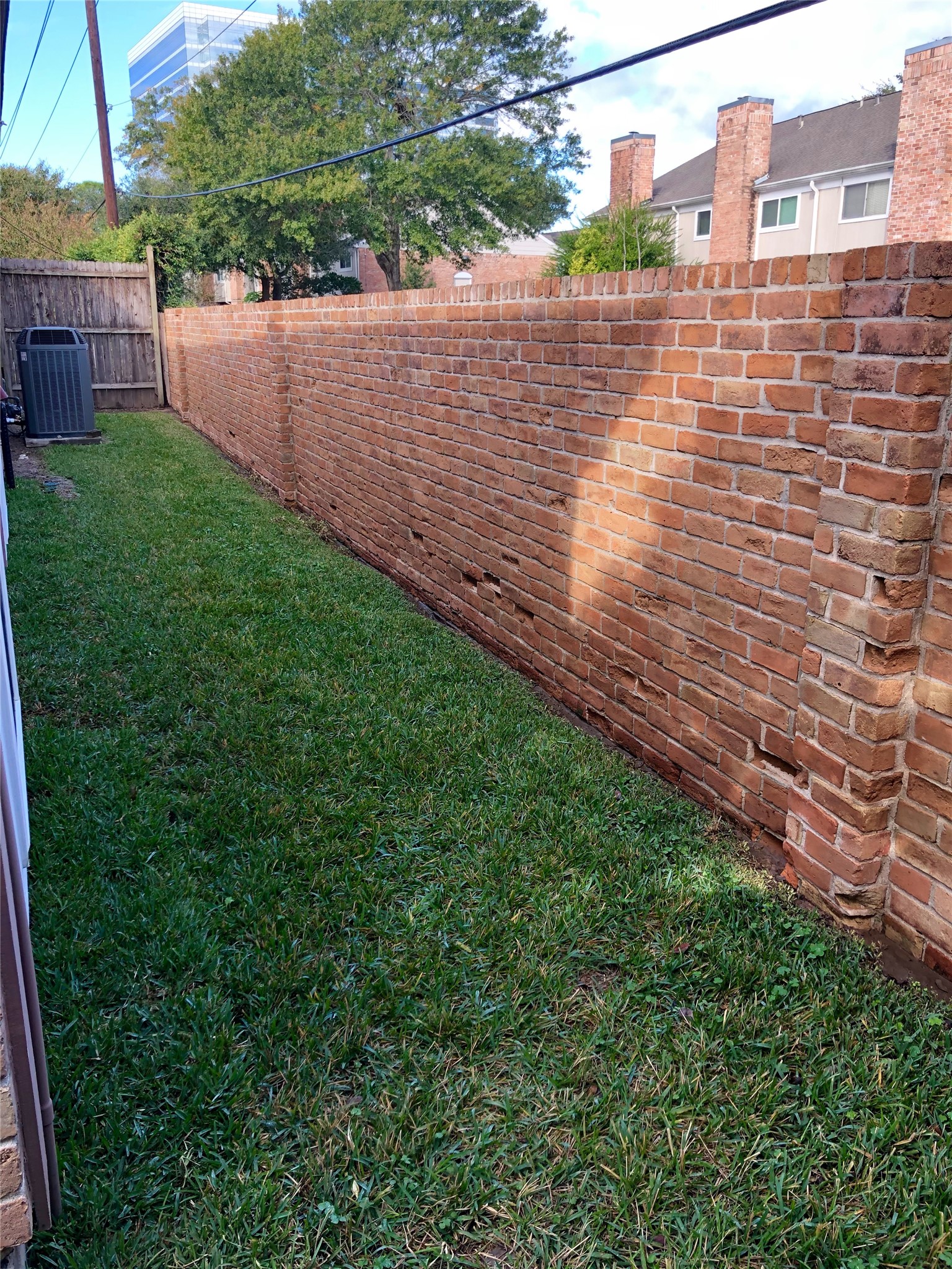 10310 Chevy Chase Drive Houston, TX 77042 - Photo 4 of 36 a view of a backyard with plants and brick wall