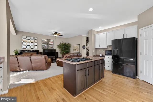 a kitchen with stainless steel appliances granite countertop a stove top oven a refrigerator and a cabinets