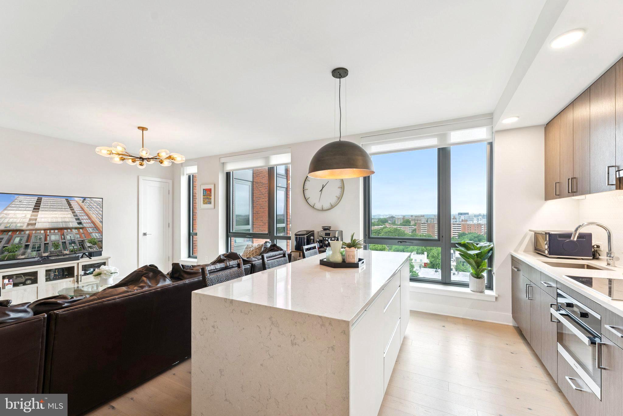 a view of a kitchen counter top a stove and a chandelier