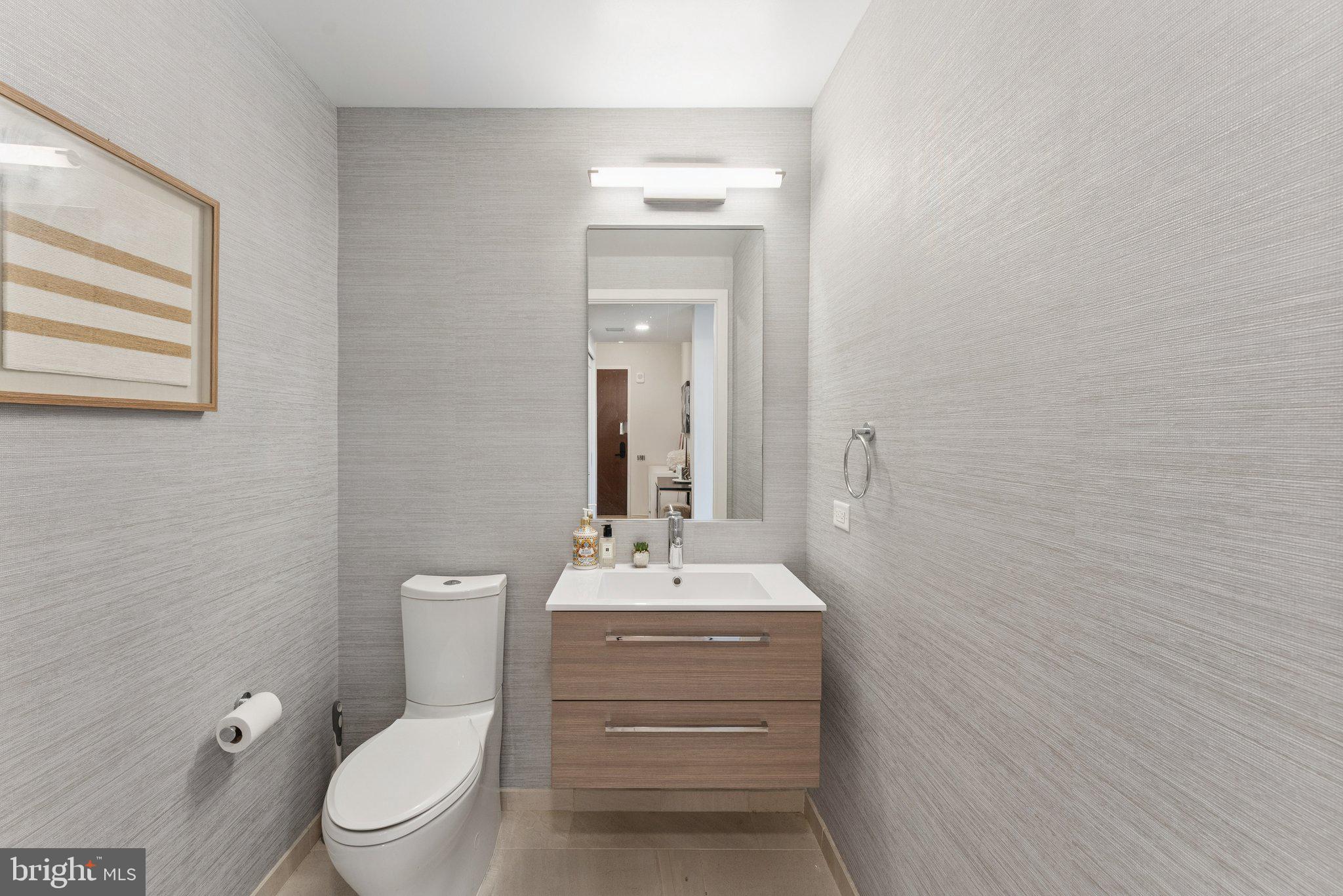 1211 Van Street Southeast, Unit 913 Washington, DC 20003 - Photo 11 of 38 a bathroom with a toilet a sink and mirror