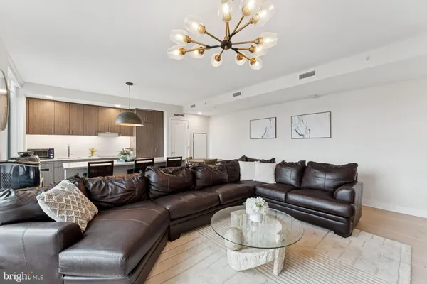 a living room with furniture a rug and a chandelier