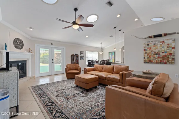 a living room with furniture kitchen view and a chandelier